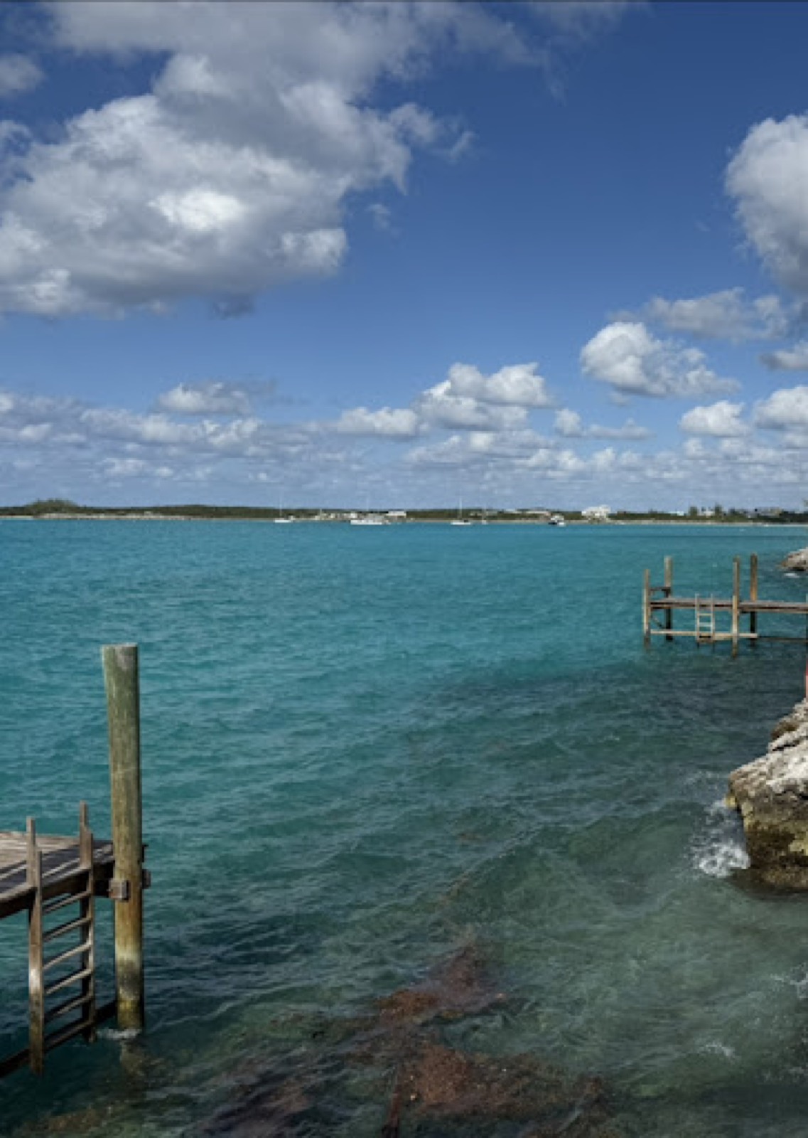 Wooden docks over turquoise water with moored boats along the Black Point shore