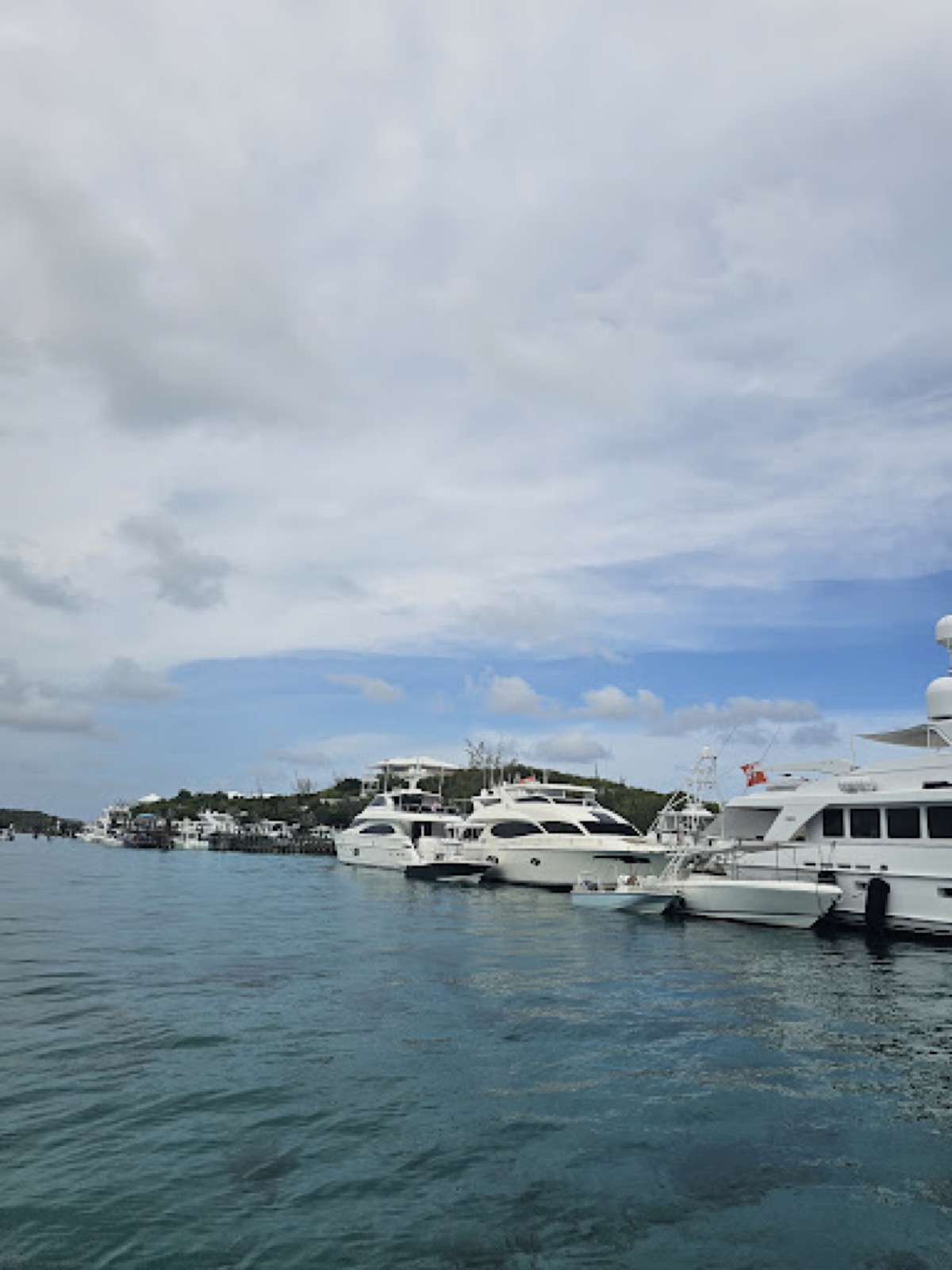 White motor yachts docked at the Staniel Cay Yacht Club marina, seen from the water