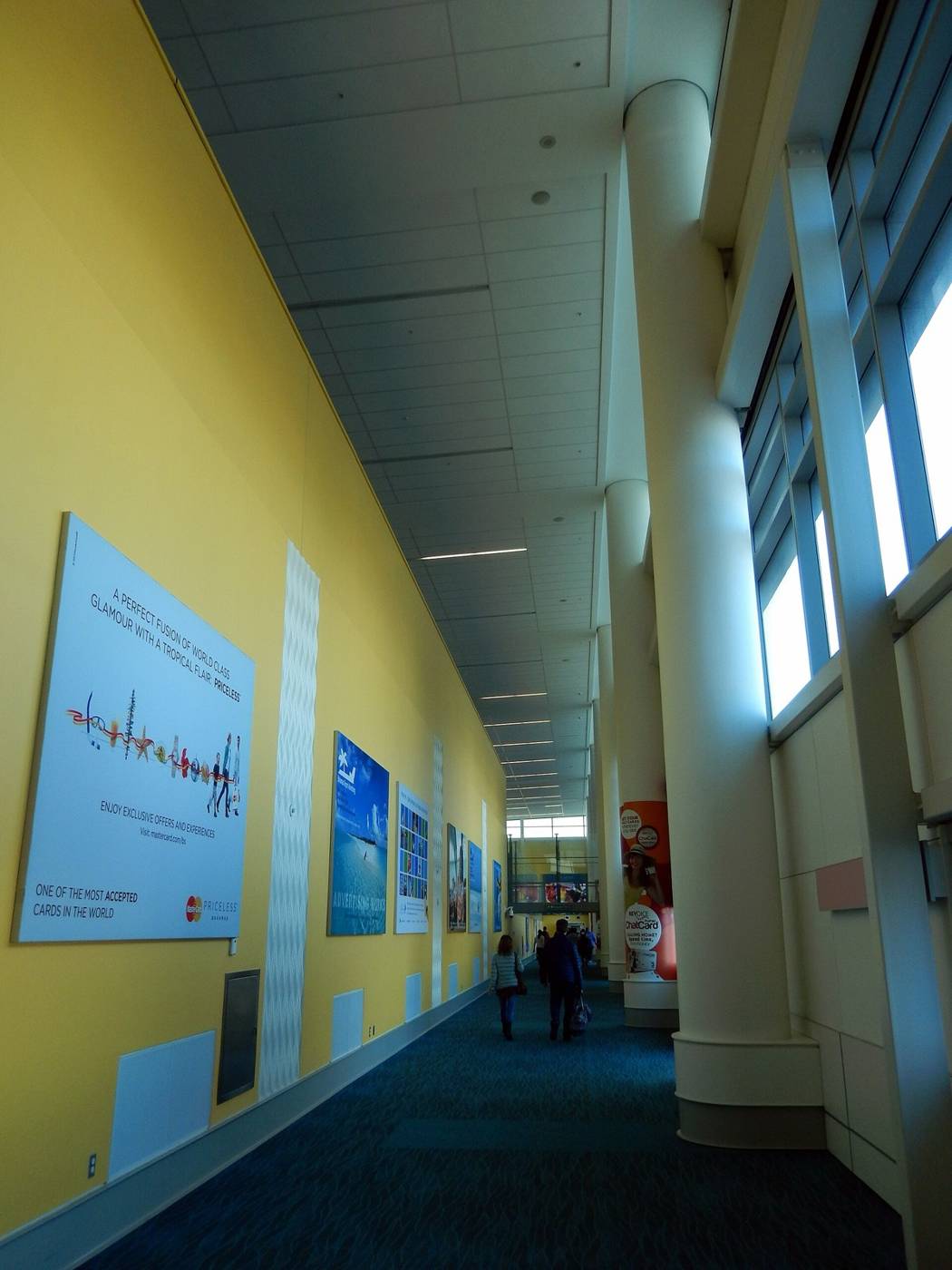 Long yellow terminal corridor at Lynden Pindling International Airport in Nassau