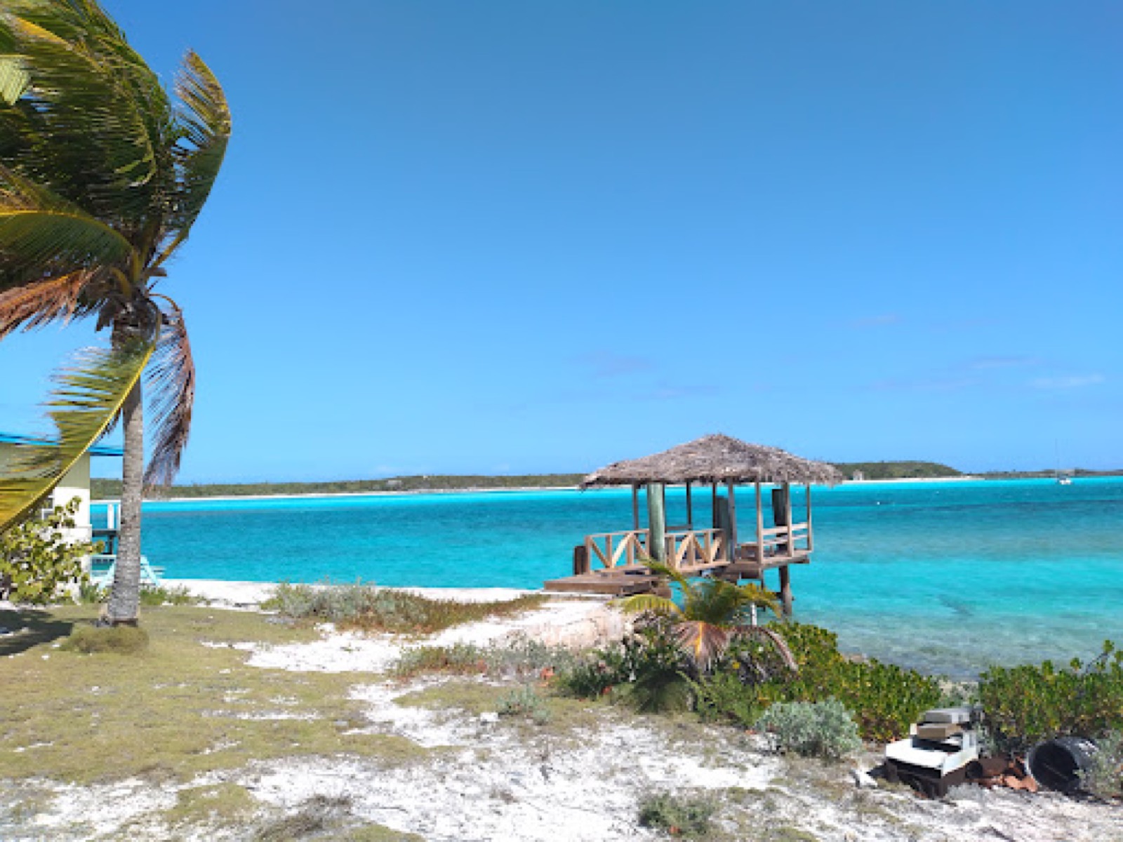 Thatched gazebo on a sandy point above turquoise water