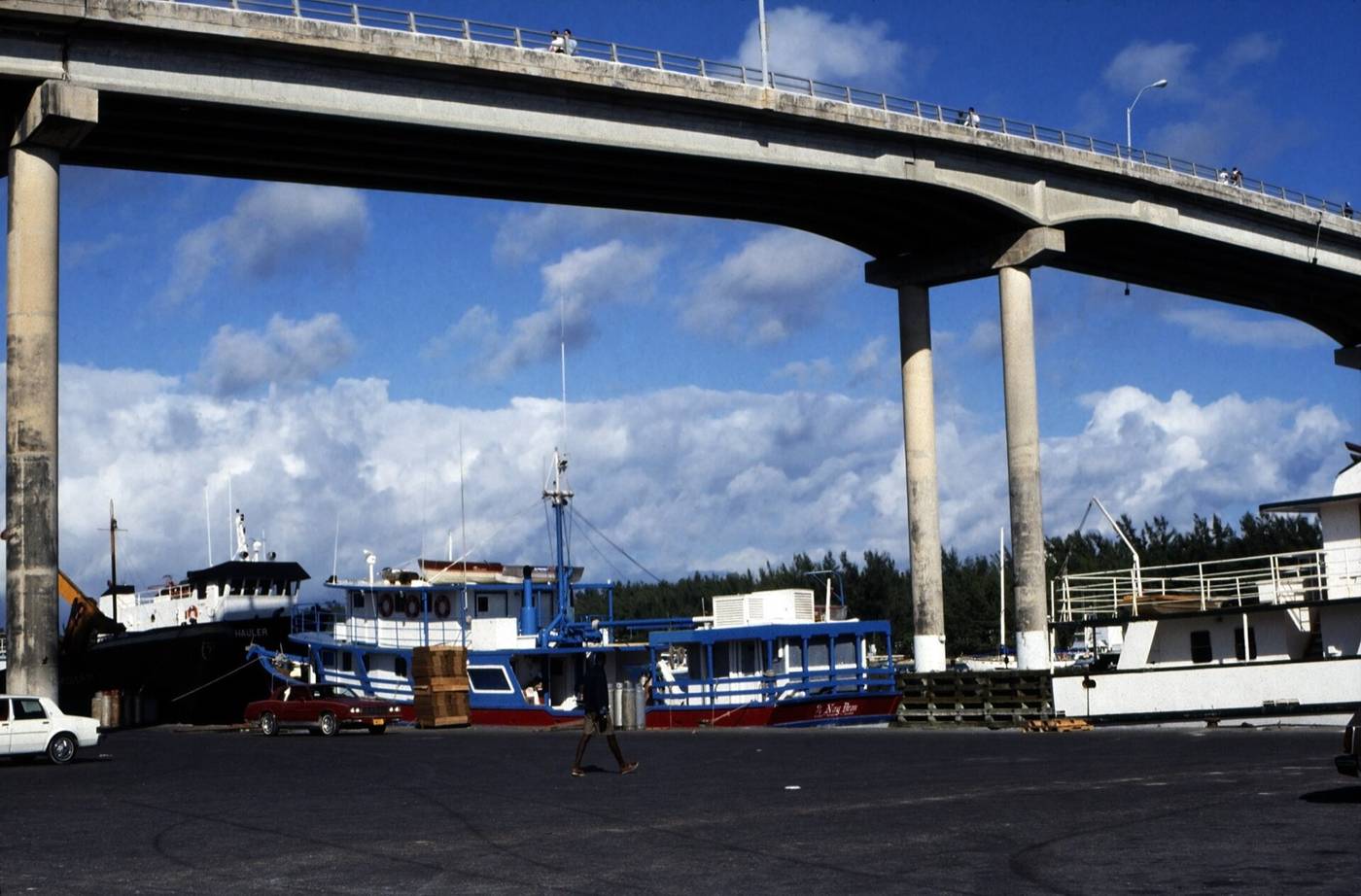 Blue and white inter-island freight boats tied up at Potters Cay under a bridge in Nassau