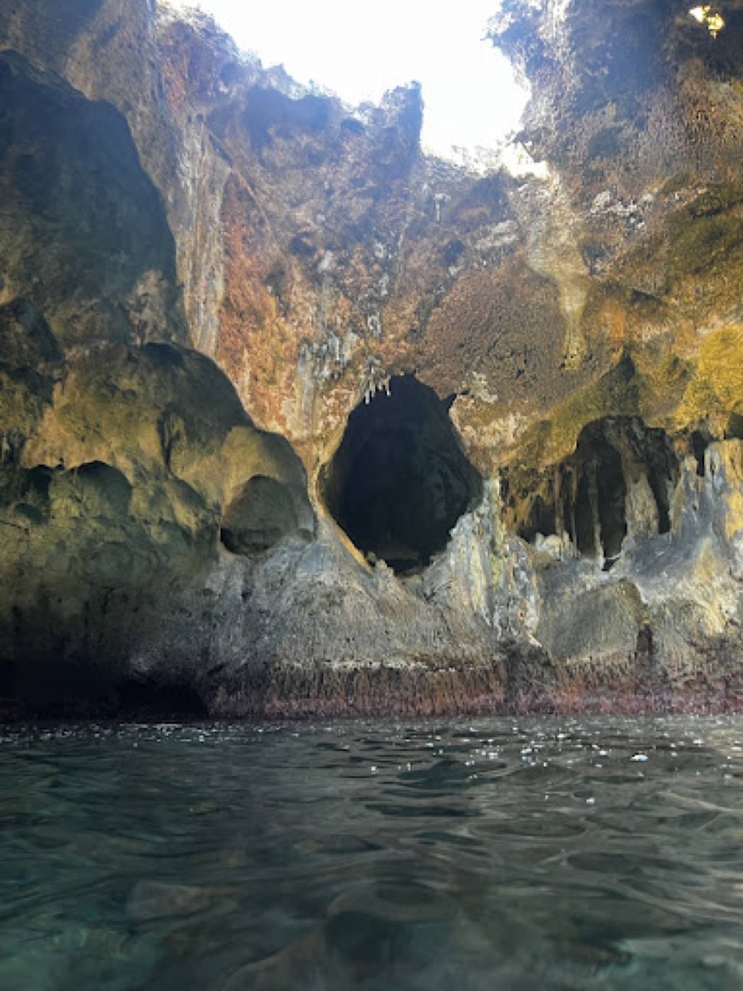 Limestone cave opening with stalactites, seen from the water at Rocky Dundas, Exuma