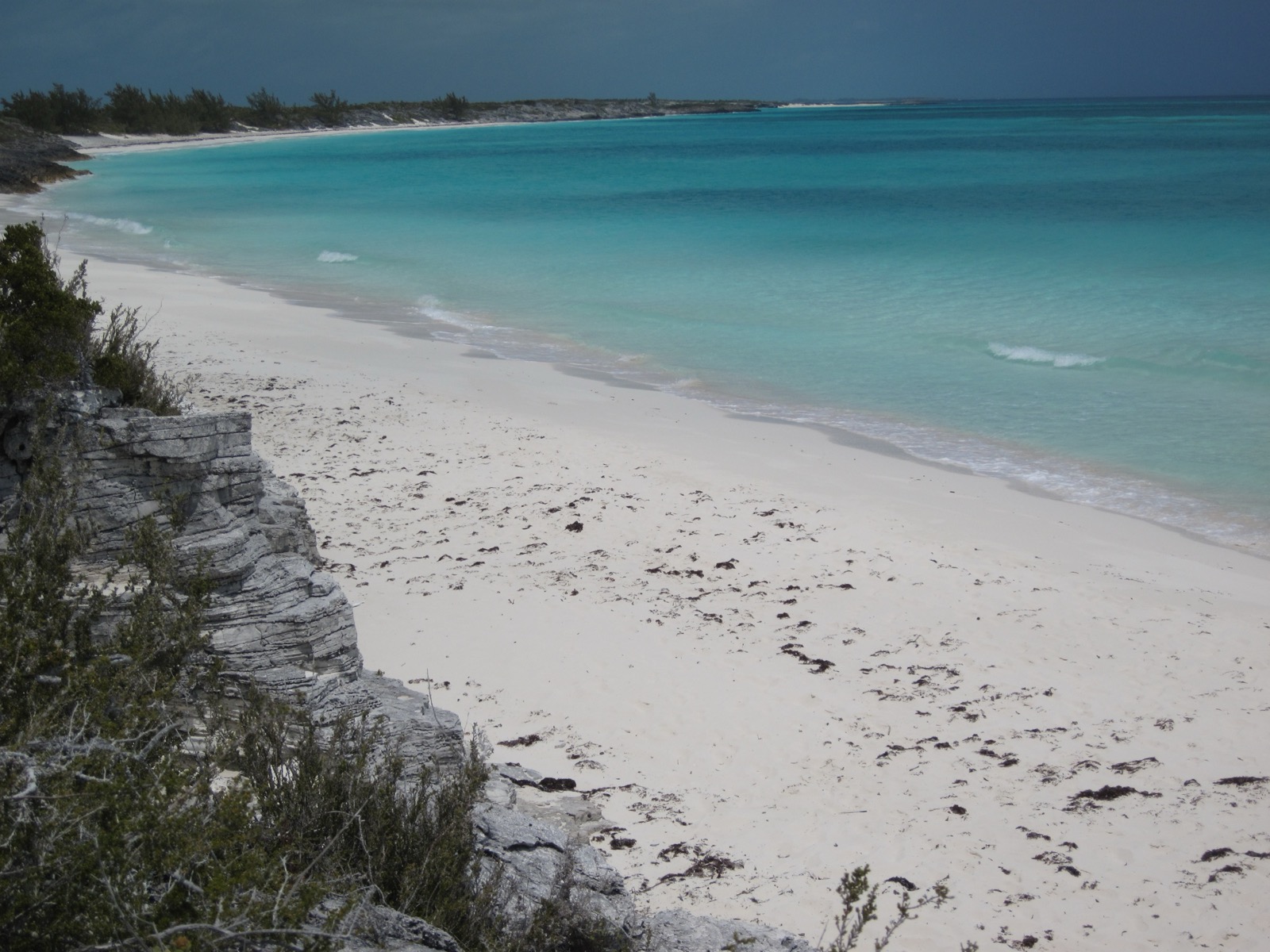 White sand beach and turquoise shallows along a pale limestone shore on Shroud Cay
